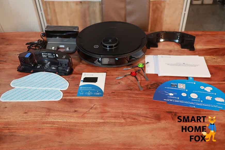 Der gesamte Lieferumfang des Ecovacs Deebtot T9 AIVI steht auf dem Tisch.